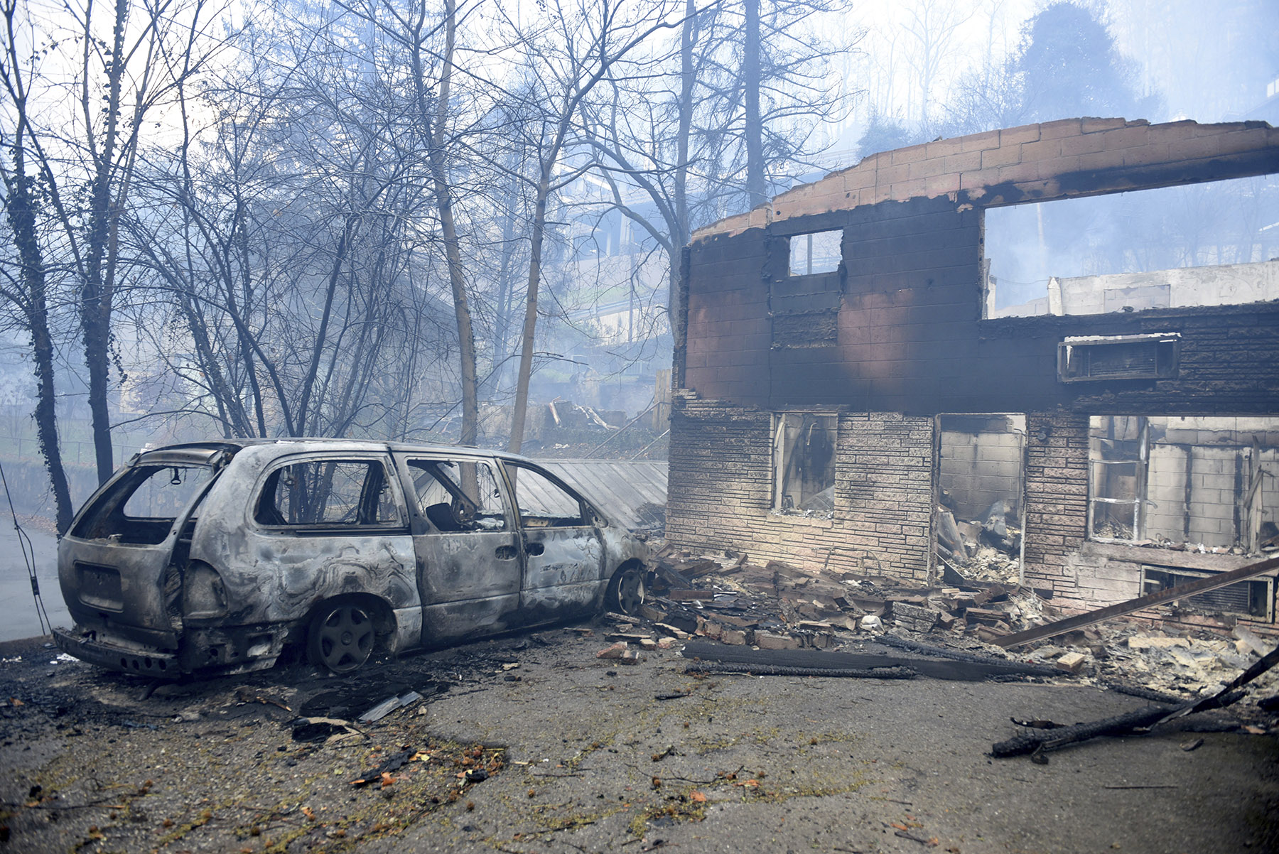 A home and vehicle are damaged from the wildfires around Gatlinburg, Tenn., on Tuesday, Nov. 29, 2016. Rain had begun to fall in some areas, but experts predicted it would not be enough to end the relentless drought that has spread across several Southern states and provided fuel for fires now burning for weeks in states including Tennessee, Georgia and North Carolina. (Michael Patrick/Knoxville News Sentinel via AP)