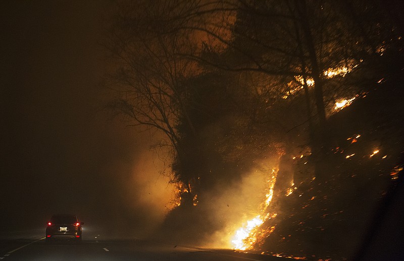 Fire erupts on the side of The Spur on Highway 441 between Gatlinburg and Pigeon Forge, Tenn., Monday, Nov. 28, 2016. In Gatlinburg, smoke and fire caused the mandatory evacuation of downtown and surrounding areas, according to the Tennessee Emergency Management Agency. (Jessica Tezak/Knoxville News Sentinel via AP)