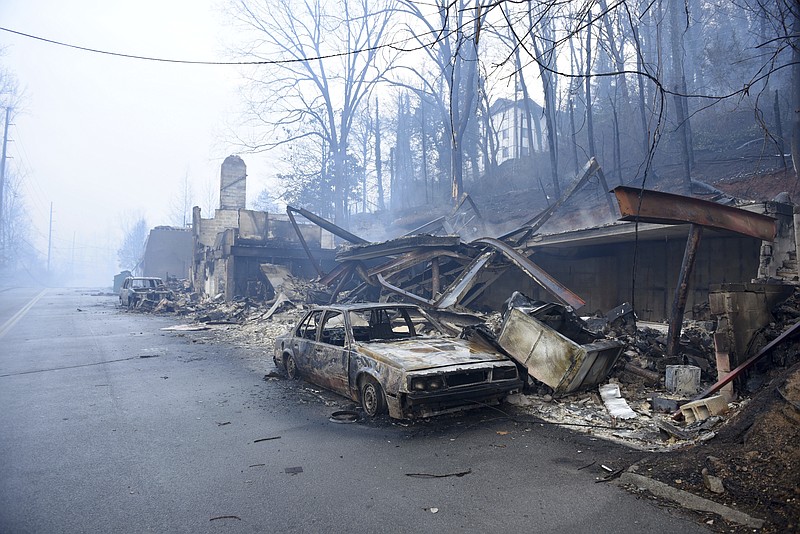 A structure and vehicle are damaged from the wildfires around Gatlinburg, Tenn., on Tuesday, Nov. 29, 2016. Rain had begun to fall in some areas, but experts predicted it would not be enough to end the relentless drought that has spread across several Southern states and provided fuel for fires now burning for weeks in states including Tennessee, Georgia and North Carolina. (Michael Patrick/Knoxville News Sentinel via AP)