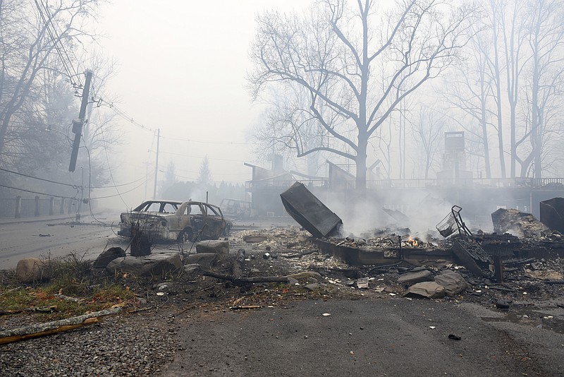 A structure and vehicle are damaged from the wildfires around Gatlinburg, Tenn., on Tuesday, Nov. 29, 2016. Rain had begun to fall in some areas, but experts predicted it would not be enough to end the relentless drought that has spread across several Southern states and provided fuel for fires now burning for weeks in states including Tennessee, Georgia and North Carolina. (Michael Patrick/Knoxville News Sentinel via AP)