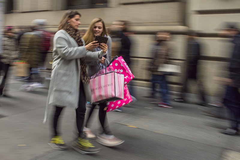 
              FILE - In this Friday, Nov. 25, 2016, file photo, shoppers carry their purchases as they walk along Fifth Avenue in New York. On Tuesday, Nov. 29, 2016, the Conference Board reports on consumer confidence for November. (AP Photo/Andres Kudacki, File)
            