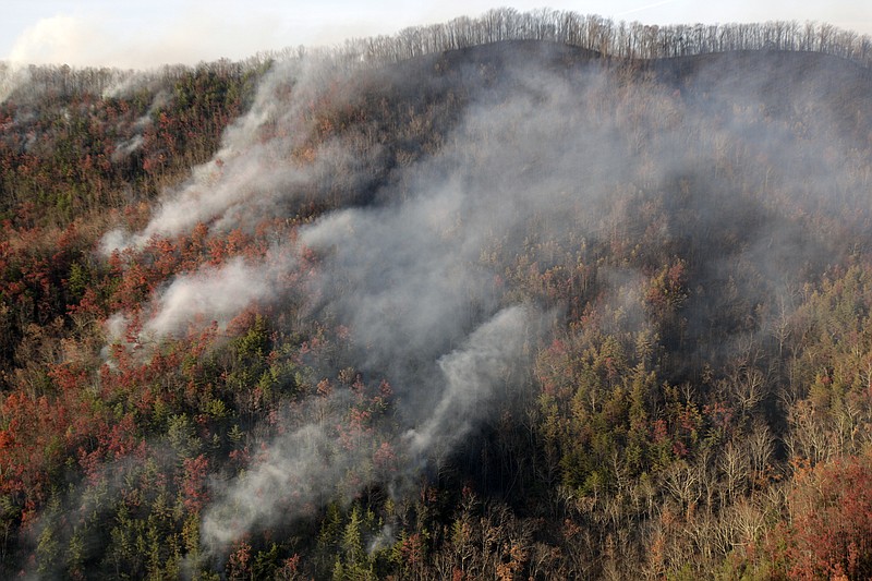 Wildfires burn Tuesday, Nov. 29, 2016, near Gatlinburg, Tenn. Thousands of people have fled wildfires that killed at least three people and destroyed hundreds of homes and a resort in the Great Smoky Mountains. (AP Photo/Wade Payne)