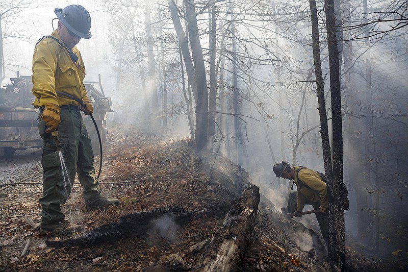 Firefighters Nate Huestis, left, and Devin Delaney with the Kansas Bureau of Indian Affairs use an engine to spray out hot spots while battling the Rough Ridge wildfire in the Cohutta Wilderness of the Chattahoochee-Oconee National Forest on Friday, Nov. 18, 2016, near Chatsworth, Ga. The wildfire, which was started by lightning in mid-October, has burned in mostly wilderness areas.