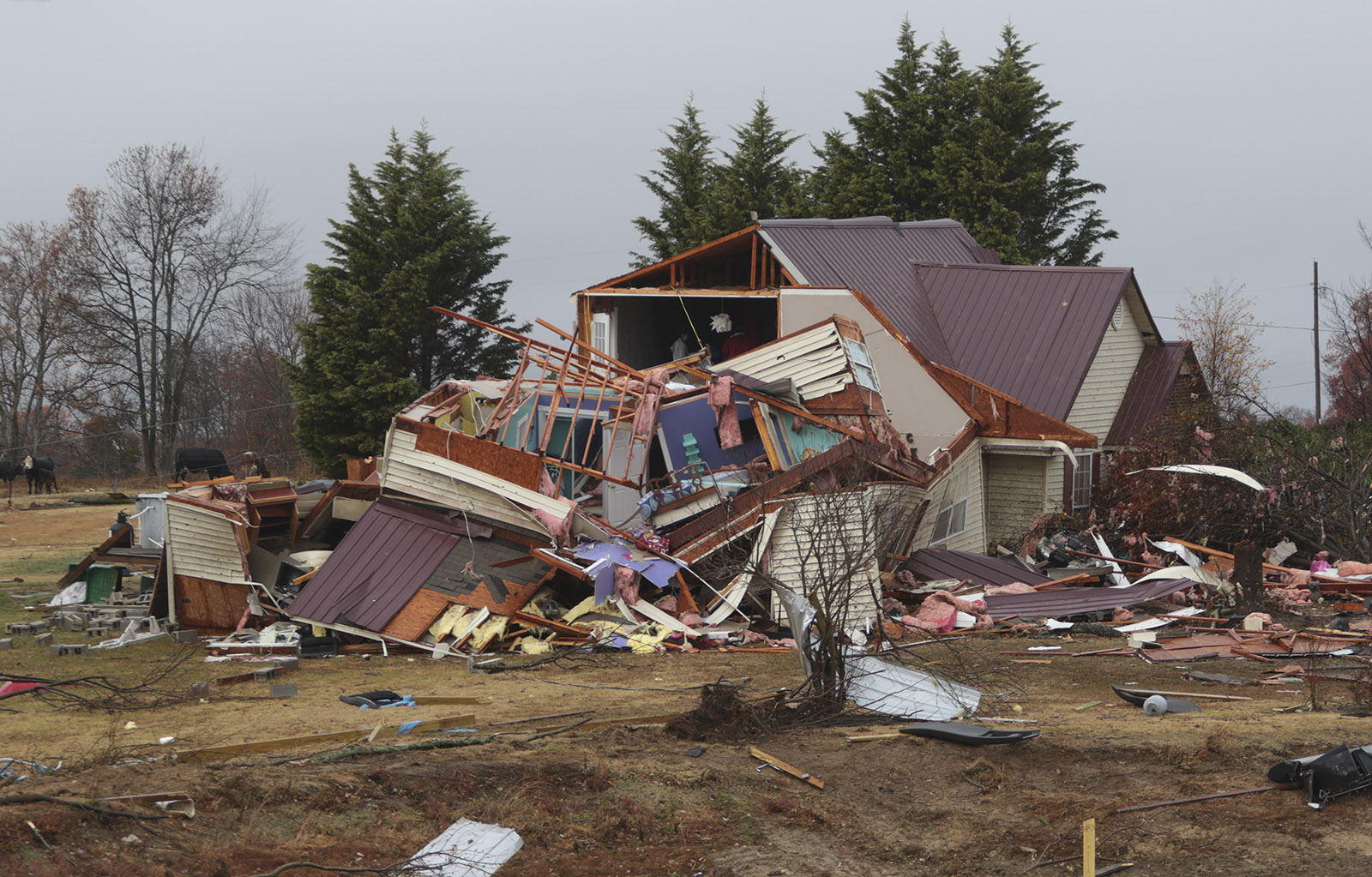 Staff Photo by Dan Henry / The Chattanooga Times Free Press- 11/30/16. Kaylan Brown and her friend Jackie Allday (top floor) scavenge for clothing in whats left of the Brown's residence after a suspetcted tornado destroyed the Ider, AL., home on Wednesday, Nov 30, 2016. The overnight storm destroyed Sand Mountain structures and killed three people in the neighboring town of Rosalie, AL.