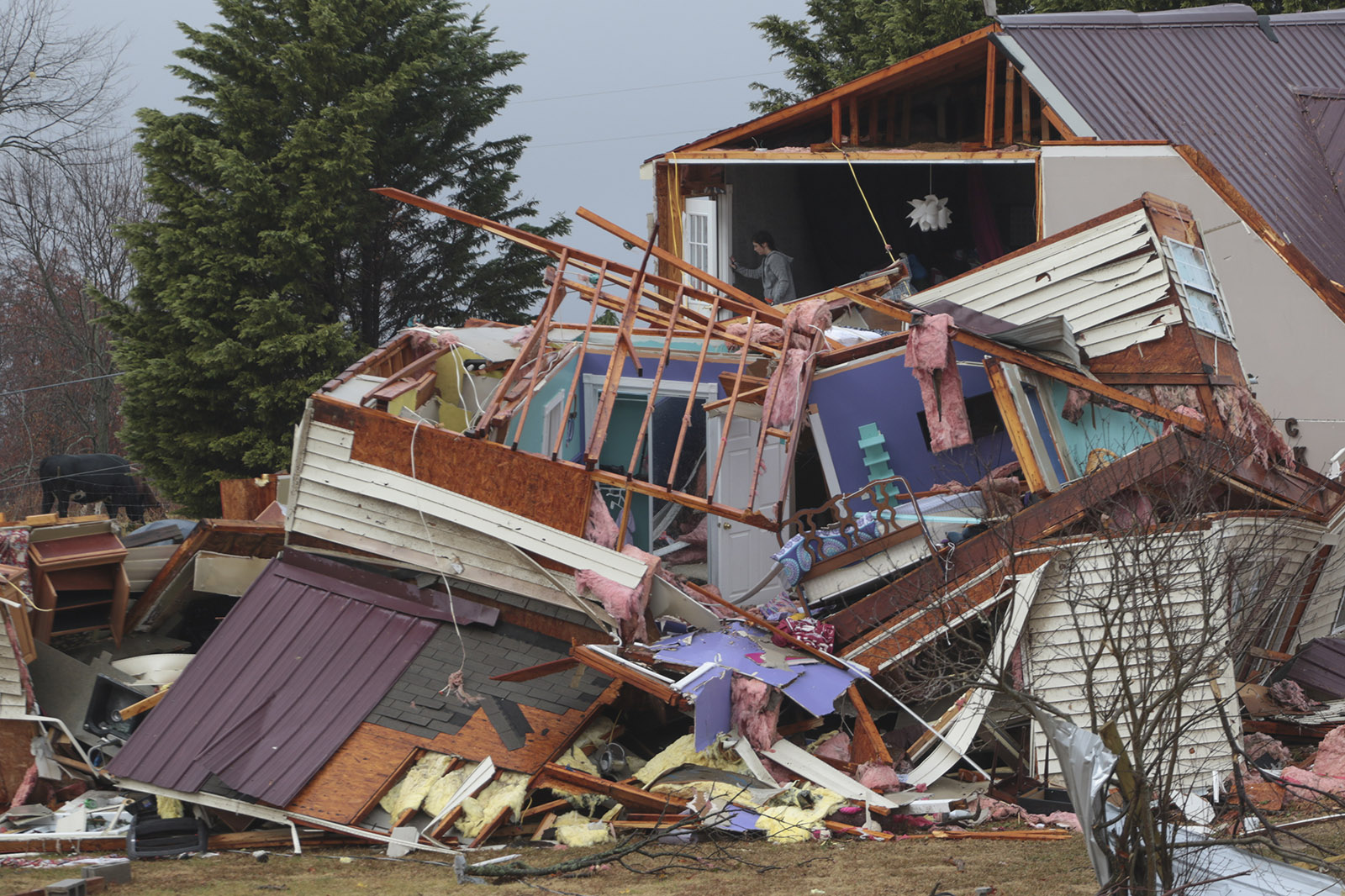 Staff Photo by Dan Henry / The Chattanooga Times Free Press- 11/30/16. Jackie Allday (top floor) helps her friend Kaylan Brown scavenge for clothing in whats left of the Brown's residence after a suspected tornado destroyed the Ider, AL., home on Wednesday, Nov 30, 2016. The overnight storm destroyed Sand Mountain structures and killed three people in the neighboring town of Rosalie, AL.
