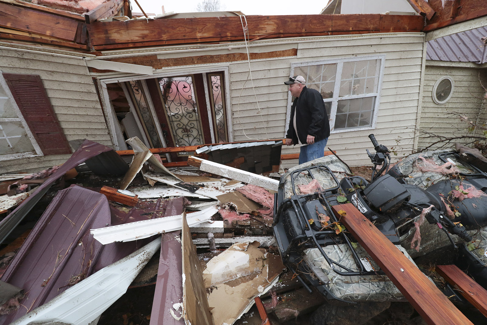 Staff Photo by Dan Henry / The Chattanooga Times Free Press- 11/30/16. Eddie Brown searches for his work boots near the front door of what's left of his family's residence after a suspected tornado destroyed the Ider, AL., home on Wednesday, Nov 30, 2016. The overnight storm destroyed Sand Mountain structures and killed three people in the neighboring town of Rosalie, AL.