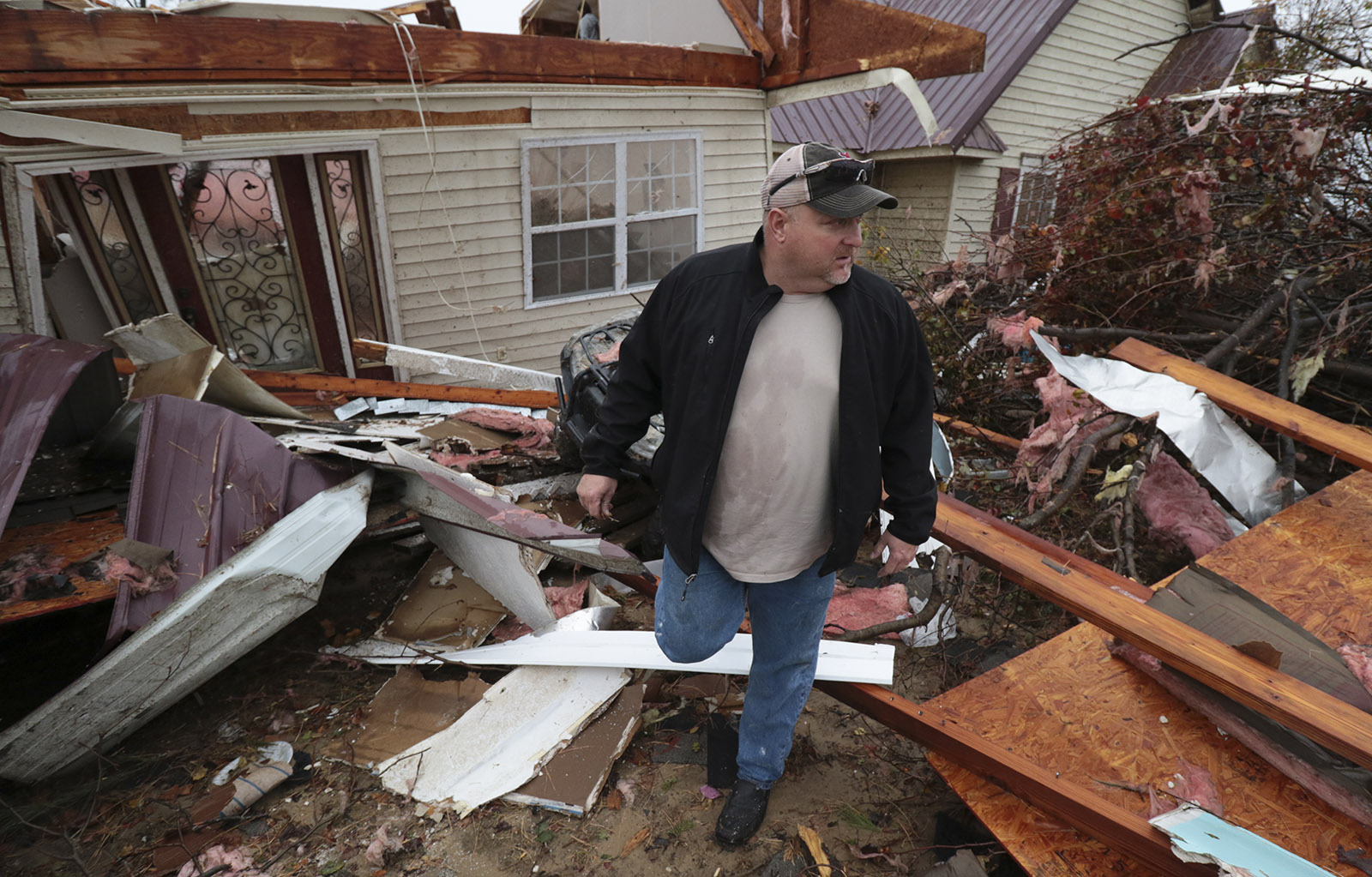 Staff Photo by Dan Henry / The Chattanooga Times Free Press- 11/30/16. Eddie Brown searches for his work boots near the front door of what's left of his family's residence after a suspected tornado destroyed the Ider, AL., home on Wednesday, Nov 30, 2016. The overnight storm destroyed Sand Mountain structures and killed three people in the neighboring town of Rosalie, AL.