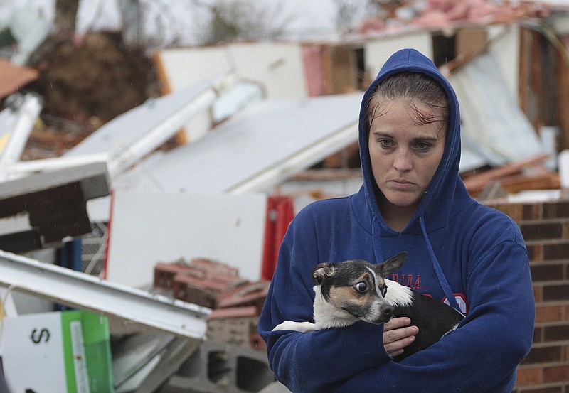 Staff Photo by Dan Henry / The Chattanooga Times Free Press- 11/30/16. Shaylyn Jeffery holds the building owner's dog "Payday" while outside of the demolished Rosalie Plaza Grocery where she had opened up a tee-shirt business one month earlier. A suspected tornado touched down overnight killing three from the Rosalie, AL., community. 