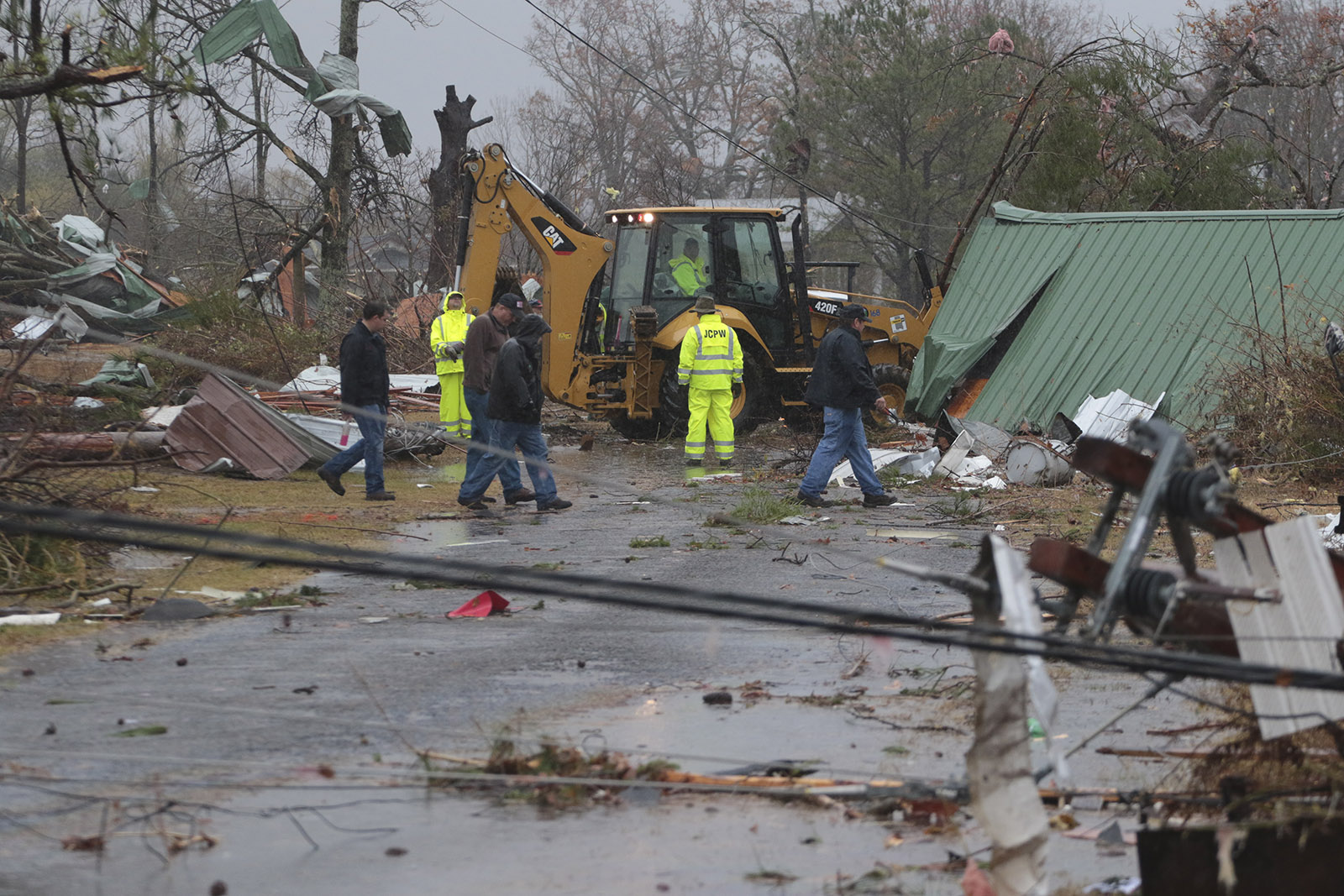 Staff Photo by Dan Henry / The Chattanooga Times Free Press- 11/30/16. Emergency personnel and utility workers clear a road of debris in Rosalie, AL, on Wednesday, Nov 30, 2016 where a suspected tornado touched down overnight killing three from the community