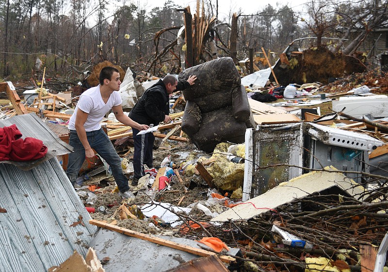 Chris Graves, left, and Clem Van Zeeland sort through items Wednesday, Nov. 30, 2016, from the remains of a mobile home where two people were killed on Stump Street in Polk County after a tornado swept through the area early Wednesday. 