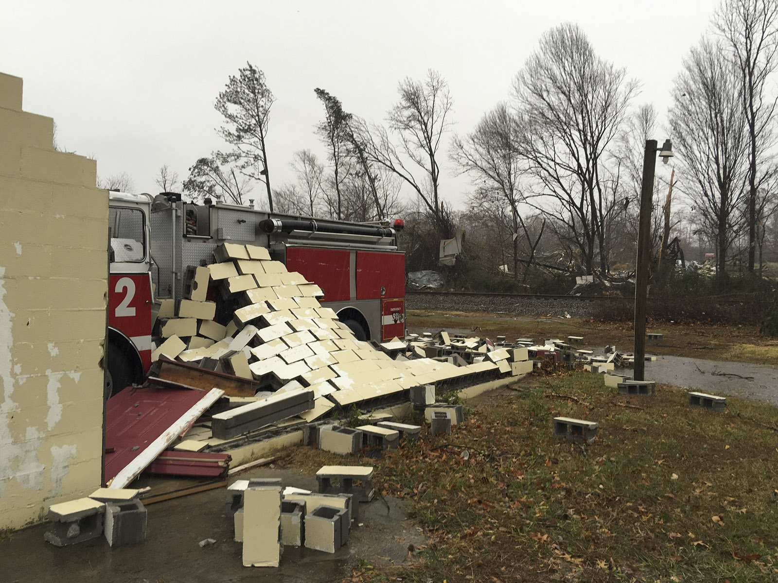 A crumbled wall rests upon a fire truck at the destroyed West Polk Fire Hall.