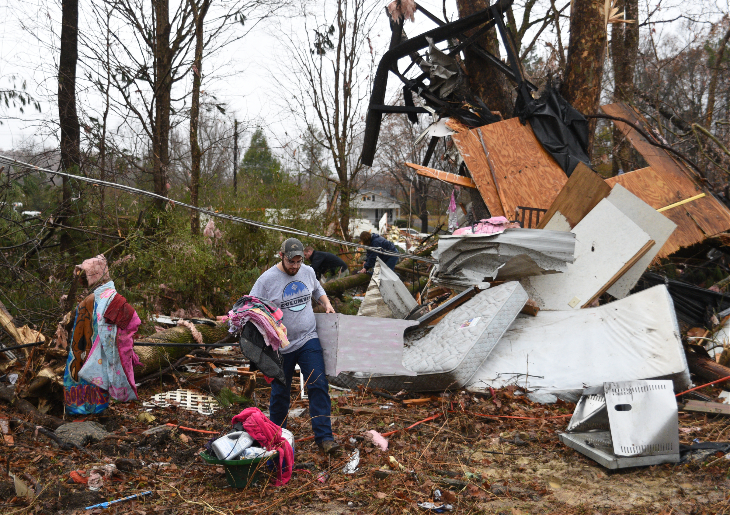 Daniel Bunch carries items from the remains of a mobile home Wednesday, Nov. 30, 2016, on Stump Street in Polk County after a tornado swept through the area early Wednesday. Casey Huston and Stephanie Breedlove lived in the home with two children, but they were not at home when the storm hit.