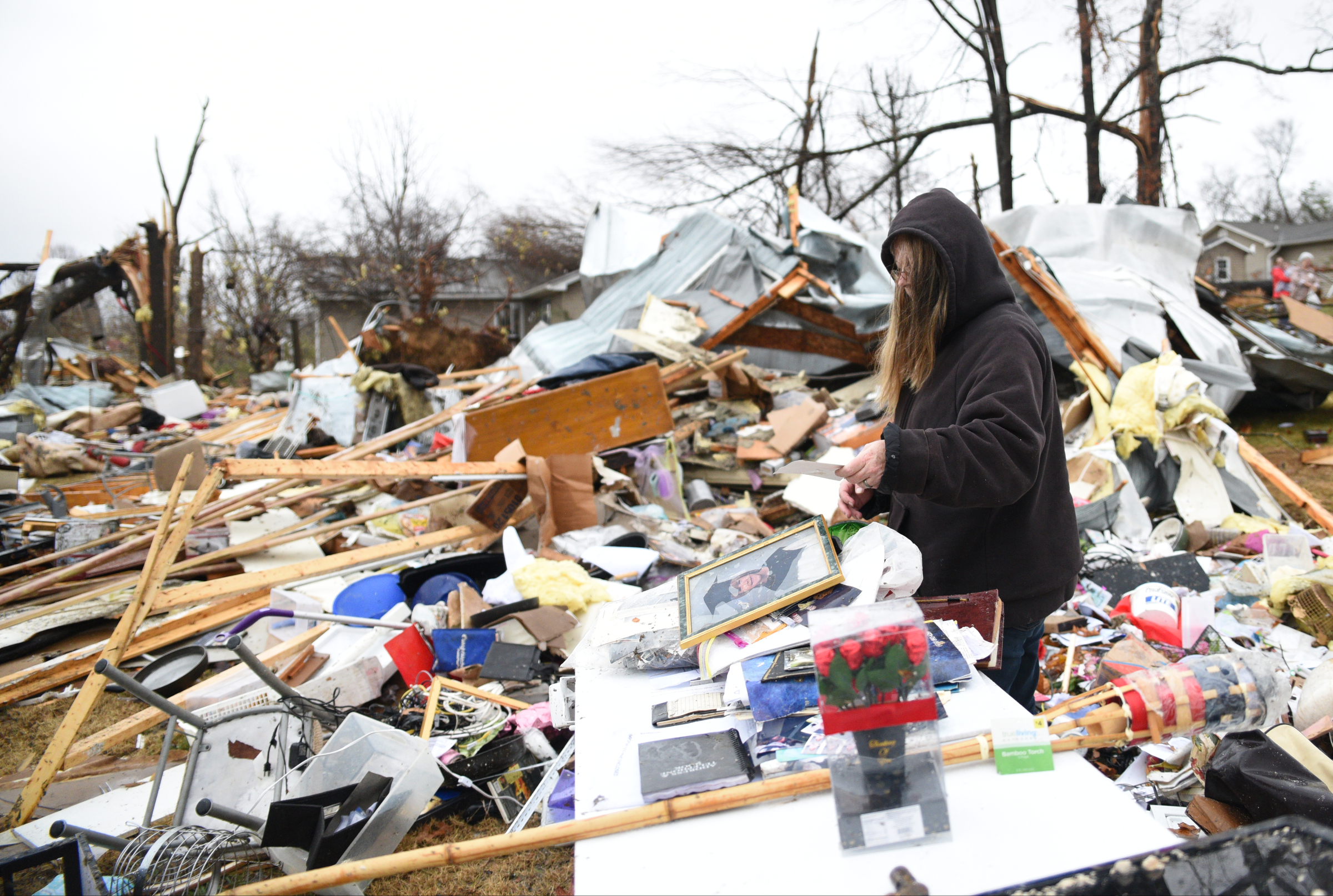 Rhonda Cooper salvages items Wednesday, Nov. 30, 2016, from the remains of a mobile home where two people were killed on Stump Street in Polk County after a tornado swept through the area early Wednesday.