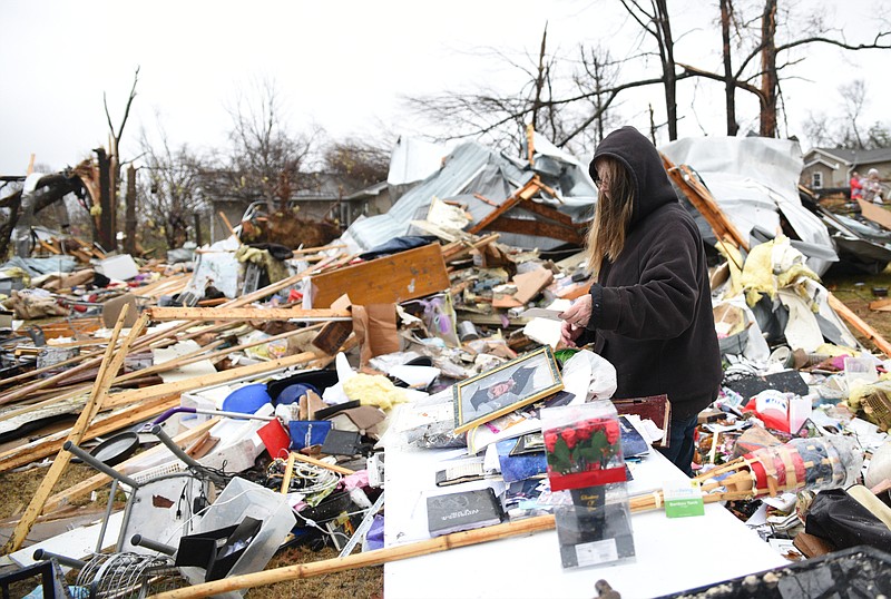 Rhonda Cooper salvages items Wednesday, Nov. 30, 2016, from the remains of a mobile home where two people were killed on Stump Street in Polk County after a tornado swept through the area early Wednesday. 