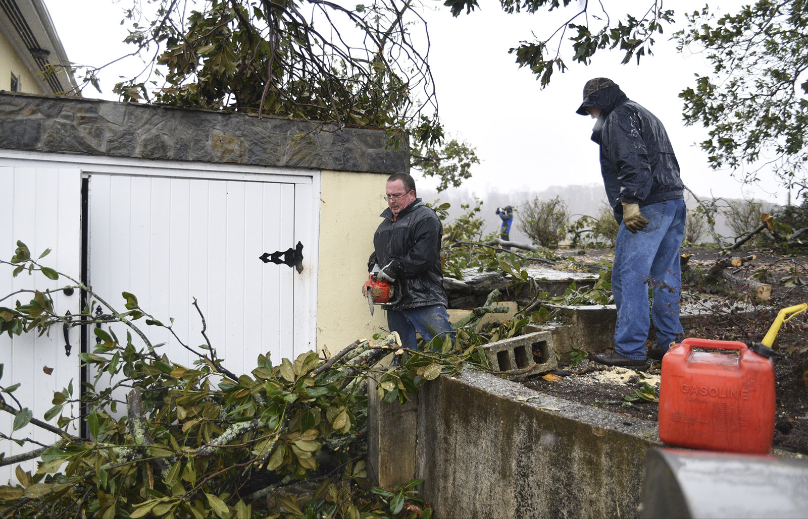 David, left, and R.C. Truelove remove limbs around a home in near South White Street in Athens, Tenn., Wednesday, Nov. 30, 2016 after a tornado swept through the area early Wednesday.