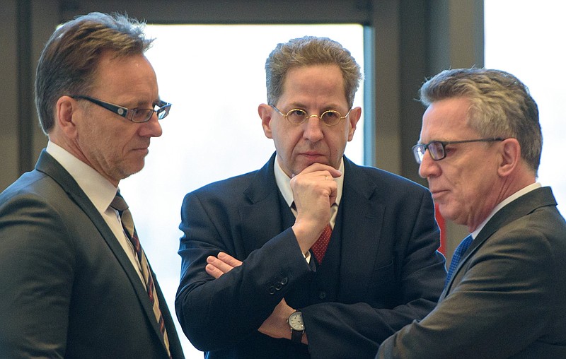 
              Hans-Georg Maassen, head of Germany's domestic intelligence service, center, listens to Interior Minister Thomas de Maiziere, right, and the head of Germany's Federal Criminal Police Office, BKA, Holger Muench, left, during a meeting of interior ministers of German federal states, in Saarbruecken, Germany, Wednesday Nov. 30, 2016. Germany's domestic intelligence service says an employee suspected of trying to pass along sensitive material to Islamic extremists had only been working for the agency for a short time.   (Oliver Dietze/dpa via AP)
            