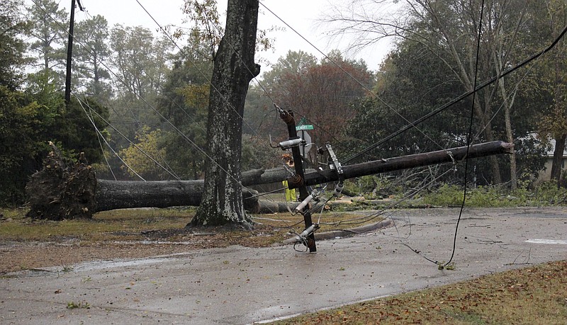 A utility pole lies across a street in north Greenwood, Miss., after it was knocked down by during a thunderstorm Monday, Nov. 28, 2016. The city also suffered power outages, additional downed trees and flash flooding. (Bob Darden/The Commonwealth via AP)