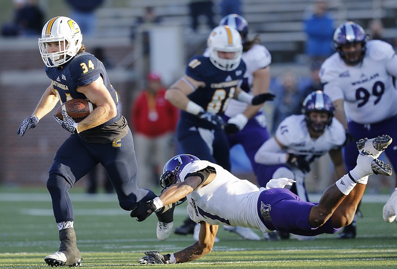 UTC running back Derrick Craine breaks a tackle by Weber State safety Josh Burton during the Mocs' first-round FCS football playoff game against Weber State at Finely Stadium on Saturday, Nov. 26, 2016, in Chattanooga, Tenn. UTC won 45-14.