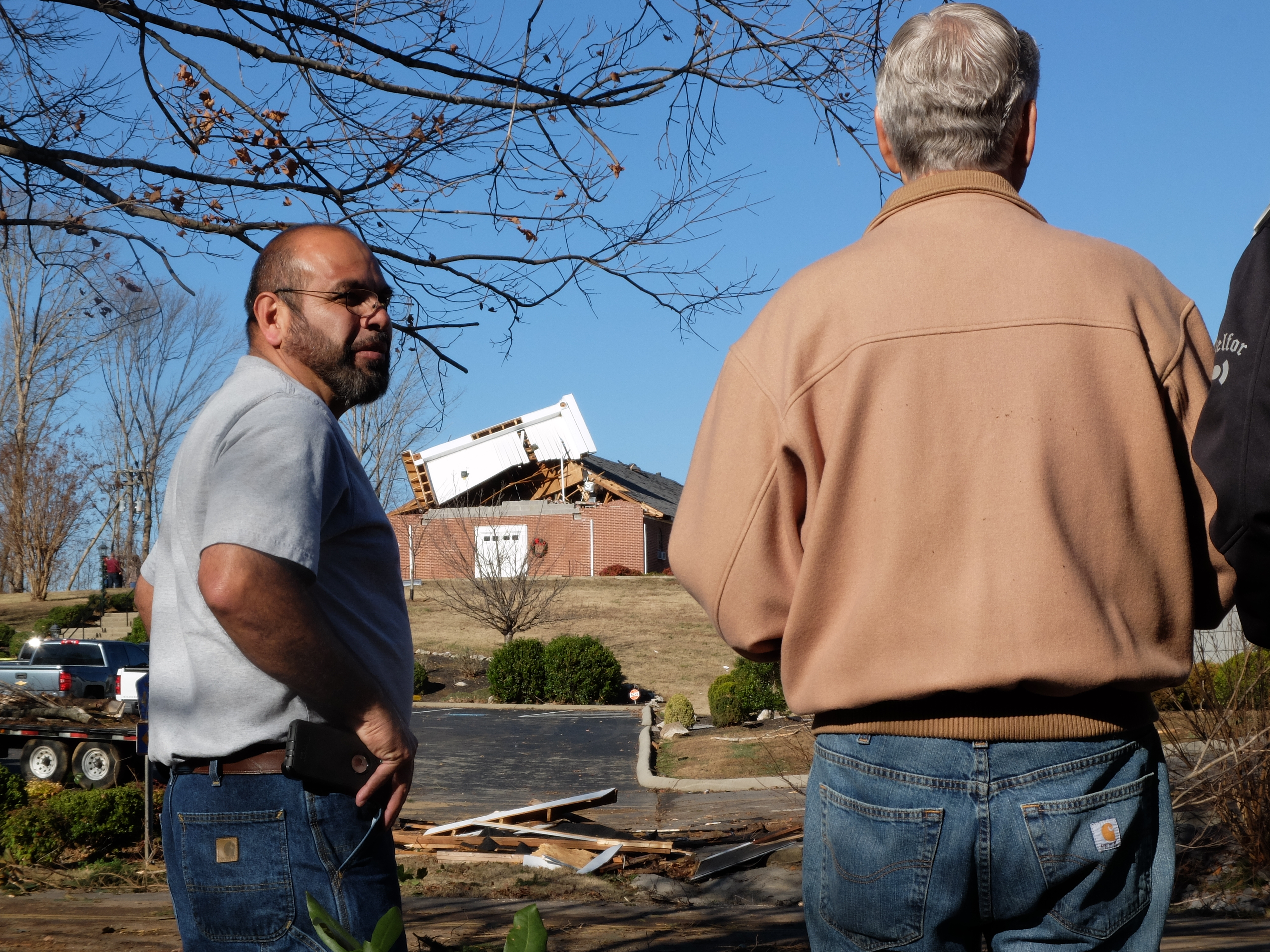 Fairview Baptist Church Pastor's Carlos Mauricio, left, and Jack Scallions, right, views the damage to the original sanctuary, atop the hill, following Wednesday's tornado just east of Athens, Tenn., on County Road 261.