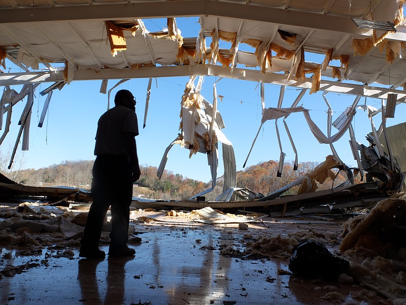 Fairview Baptist Spanish Pastor Carlos Mauricio surveys damage to the basketball gym where a tornado struck just hours after a game at Fairview Christian Academy in Athens, Tenn.