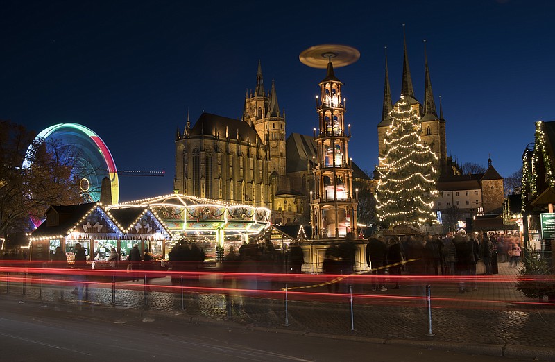 
              In this picture taken with a long time exposure people walk along the Christmas Fair in front of the Mariendom (Cathedral of Mary) and St. Severi's Church in Erfurt, central Germany, Monday, Nov. 28, 2016. The Erfurt Christmas Market is one of the most beautiful Christmas Markets in the whole of Germany. The square is beautifully decorated with a huge, candle-lit Christmas tree and a large, hand-carved wooden creche. (AP Photo/Jens Meyer)
            