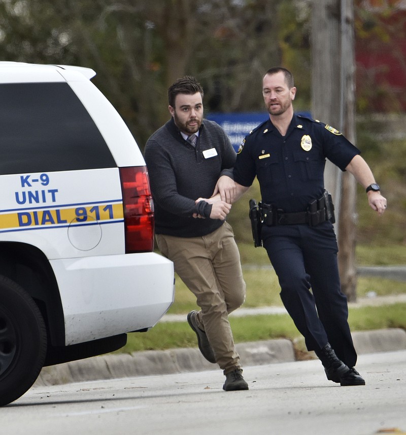 
              A police officer leads a hostage to safety during an attempted robbery at Community First Credit Union Thursday, Dec. 1, 2016, in Jacksonville, Fla. (Will Dickey /The Florida Times-Union via AP)
            
