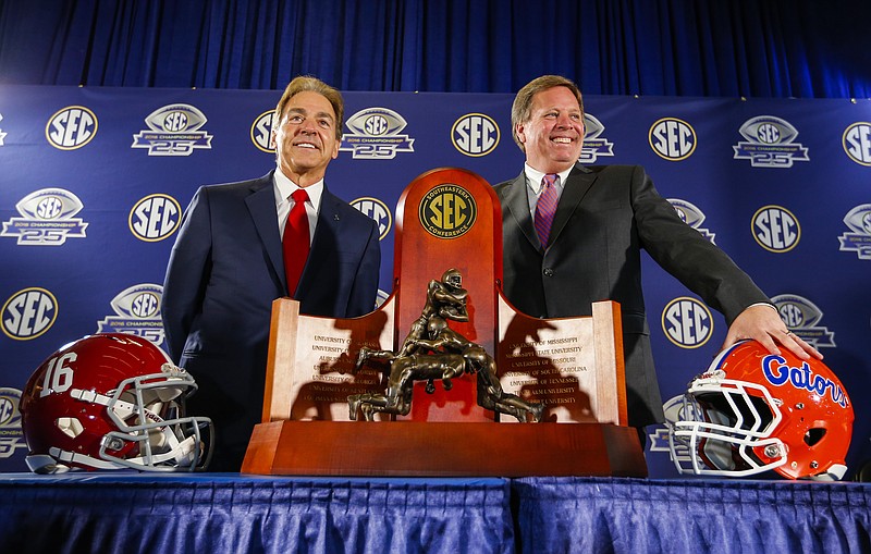 Alabama head coach Nick Saban and Florida head coach Jim McElwain pose for a photo with the trophy at the press conference for the Southeastern Conference Championship NCAA college football game, Friday, Dec. 2, 2016, in Atlanta. (AP Photo/Butch Dill)