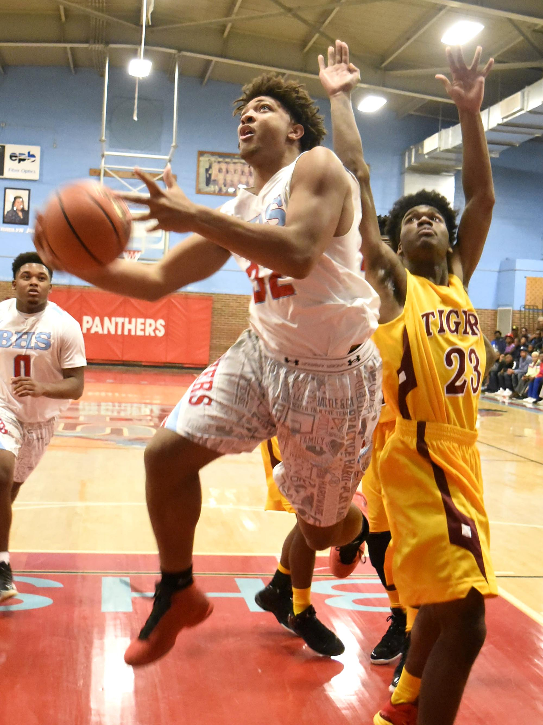 Brainerd's Jesse Walker drives inside Howard's Market Fitch (23) for a score in Friday night's 80-53 District 6-AA win for Brainerd.