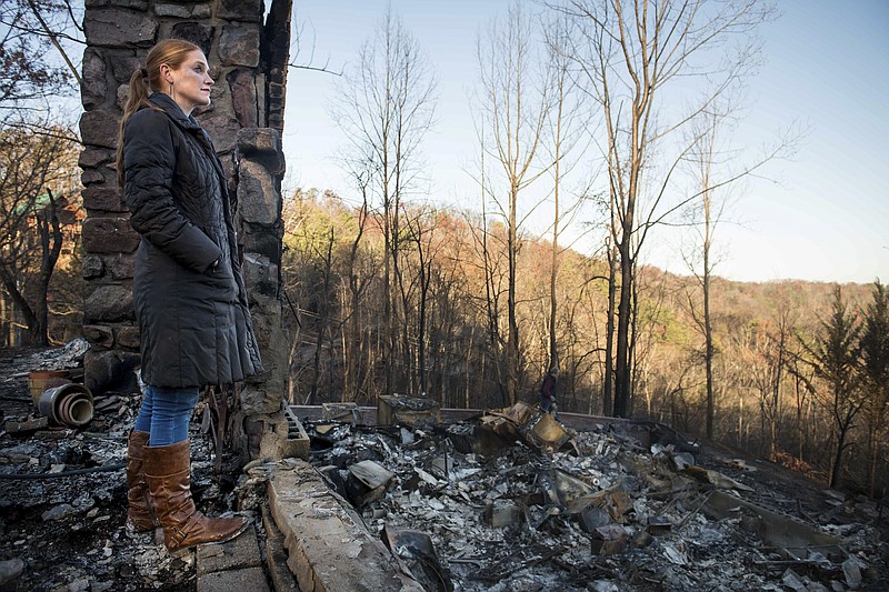 
              Veronica Carney looks at the skyline from the remains of the home she grew up in, Thursday, Dec. 1, 2016, in Gatlinburg, Tenn. Carney flew in from Massachusetts to assist her parents, Richard T. Ramsey and Sue Ramsey who safely evacuated as a wildfire approached Monday evening. (Andrew Nelles/The Tennessean via AP)
            