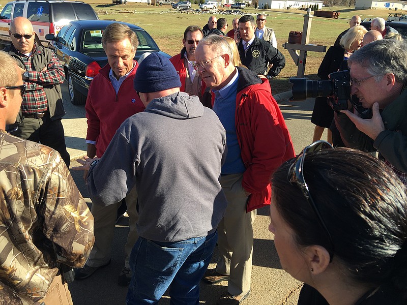 McMinn County resident Thomas Ming, in gray, demonstrates how a tornado lifted up his home as  Gov. Bill Haslam and U.S. Senator Lamar Alexander listen on Friday afternoon. 