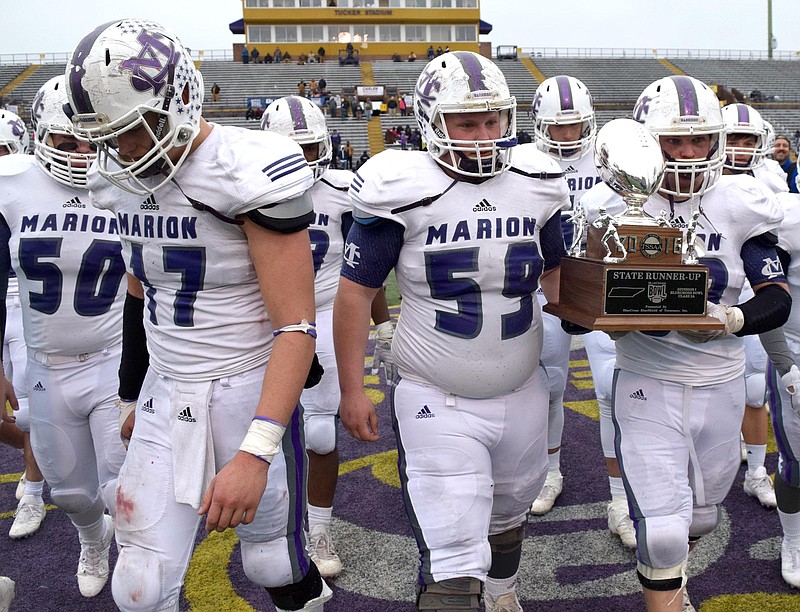 Warriors Noah Walters (50) and Alex Kirkendoll (17 leave the field as Logan Campbell (59) and Eli Morrison (58) carry the runner-up trophy.  The Marion County Warriors faced the Memphis Trezevant Bears in the Class AA TSSAA State Football Championship played in the BlueCross Bowl at Tennessee Tech in Cookeville on December 3, 2016.