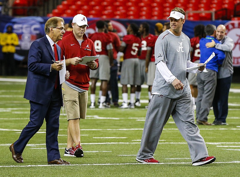 Alabama head coach Nick Saban, left,  talks with Alabama offensive coordinator Lane Kiffin, right, during practice for the Southeastern Conference Championship NCAA college football game where they will play Florida, Friday, Dec. 2, 2016, in Atlanta. (AP Photo/Butch Dill)