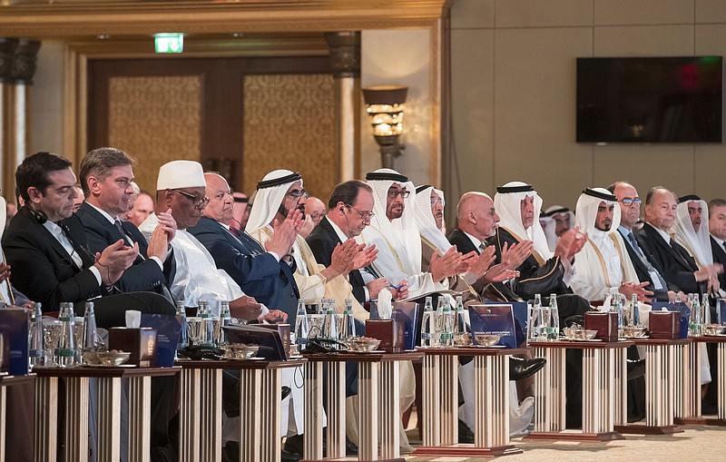
              In this Saturday Dec. 3, 2016 photo released by Emirates News Agency, WAM, French President Francois Hollande, centre, takes part between Sheikh Mohammed bin Zayed al-Nahyan, Crown Prince of Abu Dhabi and UAE's deputy commander-in-chief of the armed forces, on his right, and Sheikh Mohammed bin Rashid al-Maktoum, UAE prime minister and ruler of Dubai with the other head of states and dignitaries during the Safeguarding Endangered Cultural Heritage Conference at Emirates Palace in Abu Dhabi, United Arab Emirates. (Emirates News Agency via AP)
            