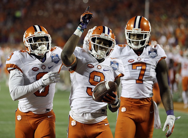 
              Clemson wide receivers Artavis Scott (3) and Mike Williams (7), congratulate running back Wayne Gallman (9) after Gallman scored a touchdown during the second half of the Atlantic Coast Conference championship NCAA college football game against Virginia Tech , Saturday, Dec. 3, 2016, in Orlando, Fla. (AP Photo/Chris O'Meara)
            