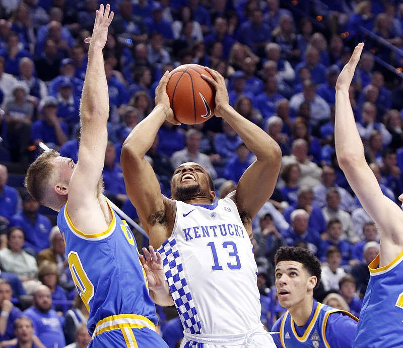 
              Kentucky's Isaiah Briscoe (13) shoots while defended by, from left, UCLA's Bryce Alford, Lonzo Ball, and Thomas Welsh during the first half of an NCAA college basketball game, Saturday, Dec. 3, 2016, in Lexington, Ky. (AP Photo/James Crisp)
            