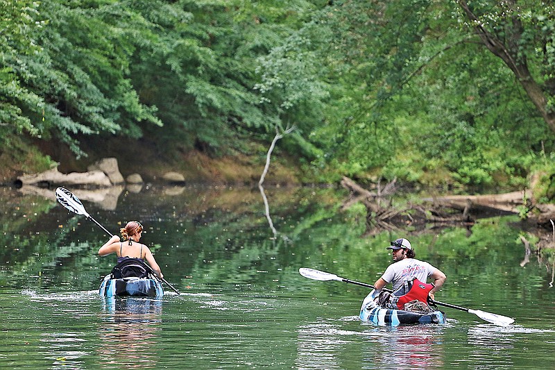 Staff Photo by Dan Henry / Andrea Jolly and Mitchell Blevins paddle downstream on Chickamauga Creek from Greenway Farms on Aug. 9.