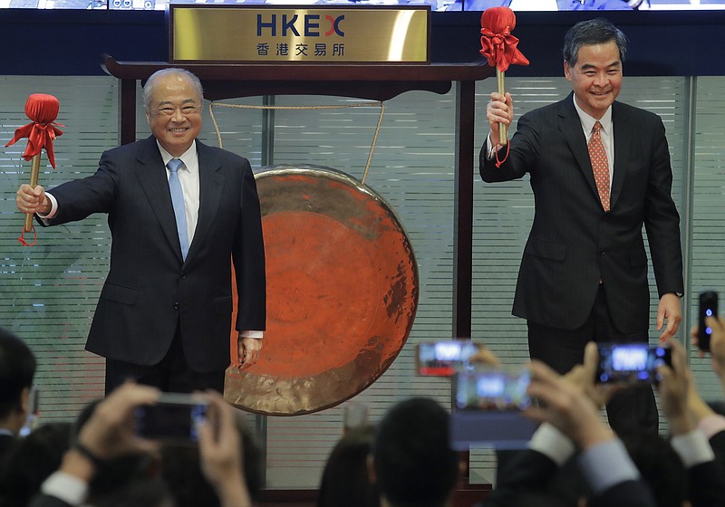 
              Hong Kong Exchanges and Clearing Ltd. Chairman Chow Chung-kong, left, and Hong Kong Chief Executive Leung Chun-ying, right, smile after beating a gong during a ceremony to launch the Shenzhen-Hong Kong Stock Connect in Hong Kong, Monday, Dec. 5, 2016. Trading began Monday on a new cross-border stock trading link between Hong Kong and the neighboring Chinese city of Shenzhen, the latest step to widen access to China's markets for global investors. (AP Photo/Vincent Yu)
            