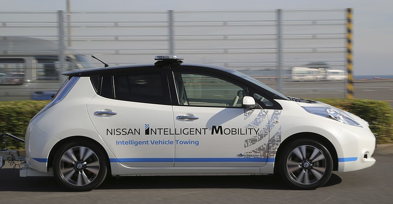 
              Nissan Motor Co.'s Leaf,  with no one inside, scoots during a demonstration of their Intelligent Vehicle Towing system at Nissan Oppama plant in Yokohama, near Tokyo Monday, Dec. 5, 2016. Nissan Motor Co. is testing out self-driving cars at one of its plants in Japan to tow vehicles on a trailer to the wharf for loading without anyone behind the steering wheel.(AP Photo/Koji Sasahara)
            