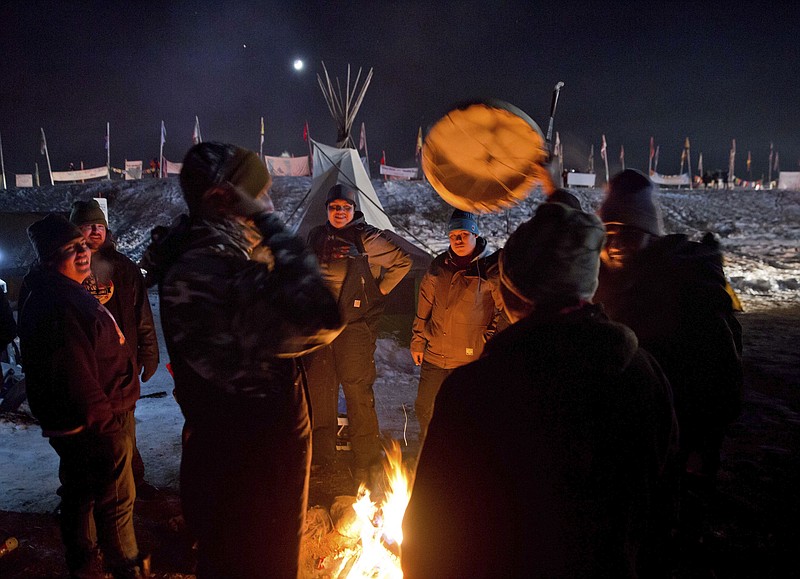 
              Campers gather around a fire to sing and drum traditional Native American social songs at the Oceti Sakowin camp where people have gathered to protest the Dakota Access oil pipeline in Cannon Ball, N.D., Sunday, Dec. 4, 2016. U.S. Army Corps of Engineers spokeswoman Moria Kelley said in a news release Sunday that the administration will not allow the four-state, $3.8 billion pipeline to be built under Lake Oahe, a Missouri River reservoir where construction had been on hold. (AP Photo/David Goldman)
            