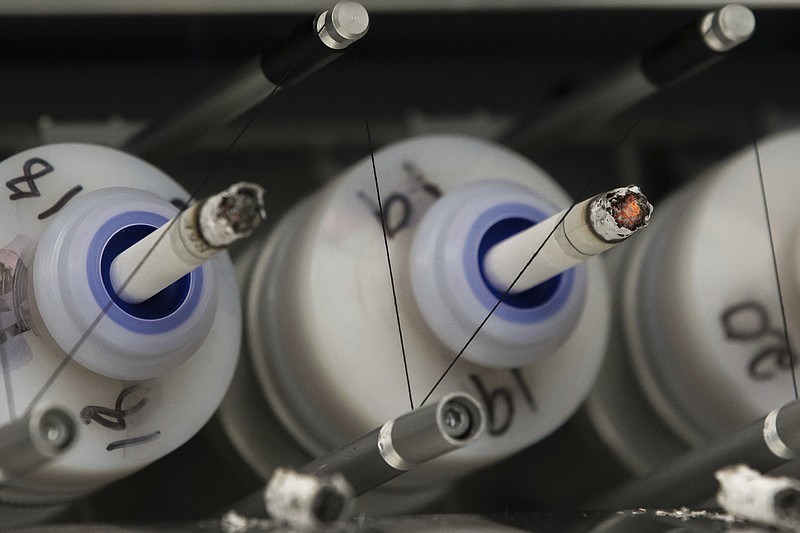 
              In this Thursday, Nov. 10, 2016 photo, test cigarettes burn in a smoking machine at the Centers for Disease Control and Prevention in Atlanta. On Monday, Dec. 5, 2016, the nation's top public health agency issued a frank assessment of its recent battles against prioritized health problems, finding progress in some areas but backslide in others. Despite the mixed grades in the CDC’s report card on itself, some experts applauded CDC efforts, saying the agency had only limited abilities to prevent illness or stop people from doing things that hurt their own health. (AP Photo/Branden Camp)
            