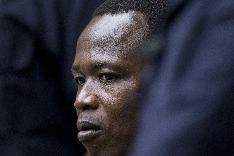 
              Dominic Ongwen, a senior commander in the Lord's Resistance Army, whose fugitive leader Kony is one of the world's most-wanted war crimes suspects, is flanked by two security guards as he sits in the court room of the International Court in The Hague, Netherlands, Tuesday, Dec. 6, 2016. (AP Photo/Peter Dejong, Pool)
            