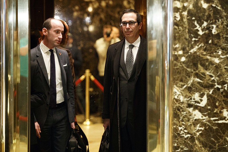 Steve Mnuchin, a Donald Trump pick to serve as treasury secretary, right, and Stephen Miller, a policy adviser to President-elect Trump, get on an elevator at Trump Tower, in late-November. (AP Photo/ Evan Vucci)
