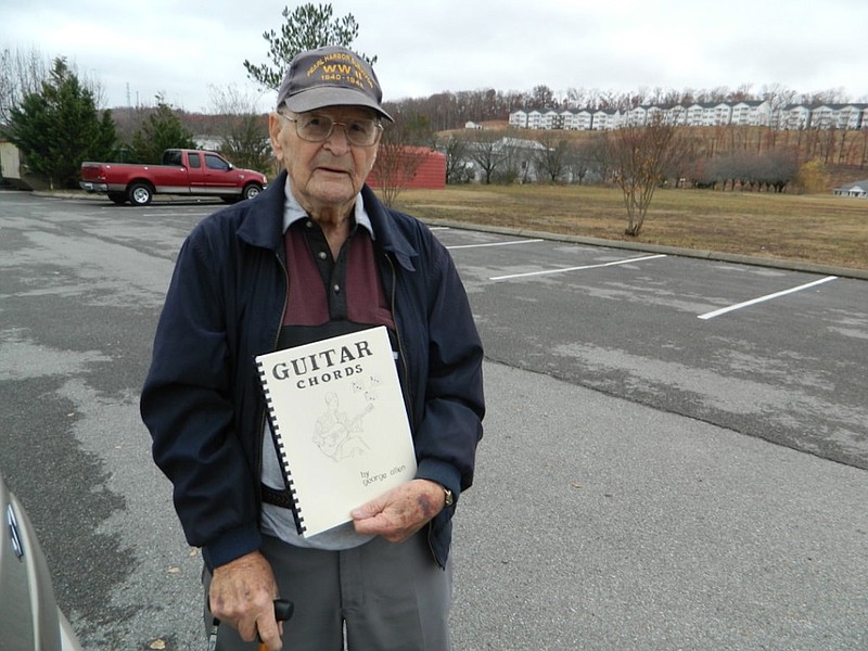 Pearl Harbor attack survivor George Allen, an accomplished musician and arranger, displays a copy of one of his instructional manuals. After his discharge in 1945, Allen began a 55-year career in the music industry.