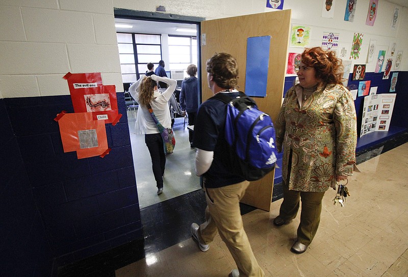 Leah Keith-Houle holds the door as students enter her GIS mapping class at Red Bank High School on Thursday, October 30, 2014. Keith-Houle's class is using Open Street Mapping to locate residential structures in Africa which will aid health workers in locating and quarantining Ebola patients.