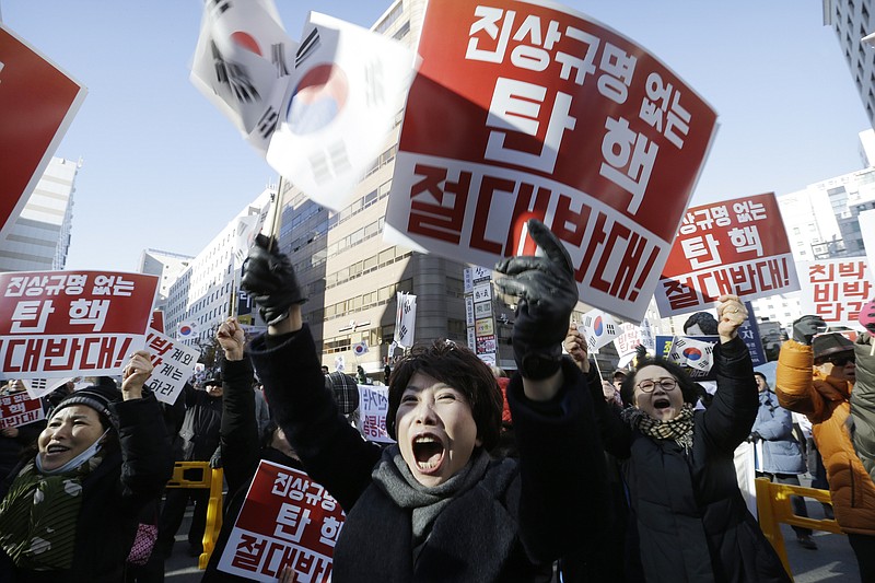 
              Protesters supporting South Korean President Park Geun-hye shout slogans during a rally opposing the impeachment of South Korean President Park Geun-hye in front of the ruling Saenuri Party headquarters in Seoul, South Korea, Tuesday, Dec. 6, 2016. South Korea is entering potentially one of the most momentous weeks in its recent political history, with impeachment looming for Park as ruling party dissenters align with the opposition in a strengthening effort to force her out. The letters read "Oppose the impeachment. " (AP Photo/Ahn Young-joon)
            