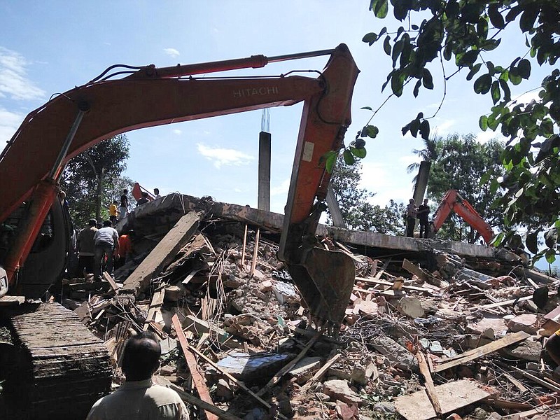 
              Rescuers use heavy machine to search for survivors under the rubble of a collapsed building after an earthquake in Pidie Jaya, Aceh province, Indonesia, Wednesday, Dec. 7, 2016. A strong undersea earthquake rocked Indonesia's Aceh province early on Wednesday, killing at a number of people and causing dozens of buildings to collapse. (AP Photo/Heri Juanda)
            