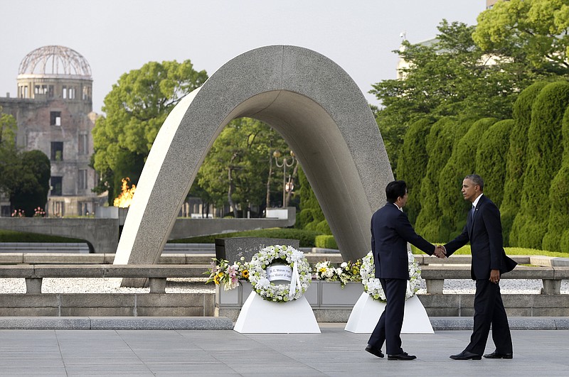  In this May 27, 2016, file photo, U.S. President Barack Obama, right, shakes hands with Japanese Prime Minister Shinzo Abe at Hiroshima Peace Memorial Park in Hiroshima, western Japan, as Obama became the first sitting U.S. president to visit the site of the world's first atomic bomb attack. Abe said Monday, Dec. 5, he will visit Pearl Harbor with Obama at the end of this month, becoming the first leader of his country to go to the U.S. Naval base in Hawaii that Japan attacked in 1941, propelling the United States into World War II. Atomic Bomb Dome is seen in the background.