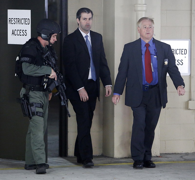 Michael Slager, center, walks from the Charleston County Courthouse under the protection from the Charleston County Sheriff's Department during a break in the jury deliberations in his trial Monday, Dec. 5, 2016, in Charleston, S.C. Slager, a former North Charleston police officer, is charged with murder in the shooting death last year of Walter Scott.