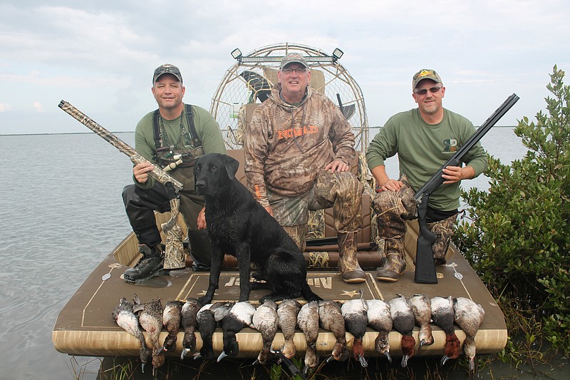 Outdoors columnist Larry Case recently took part in a whirlwind hunting and fishing trip on the Texas coast. From left are Lt. Game Warden Kevin Glass of the Texas Parks and Wildlife Department, Trigger, Case and Dave Miller from CZ-USA firearms.