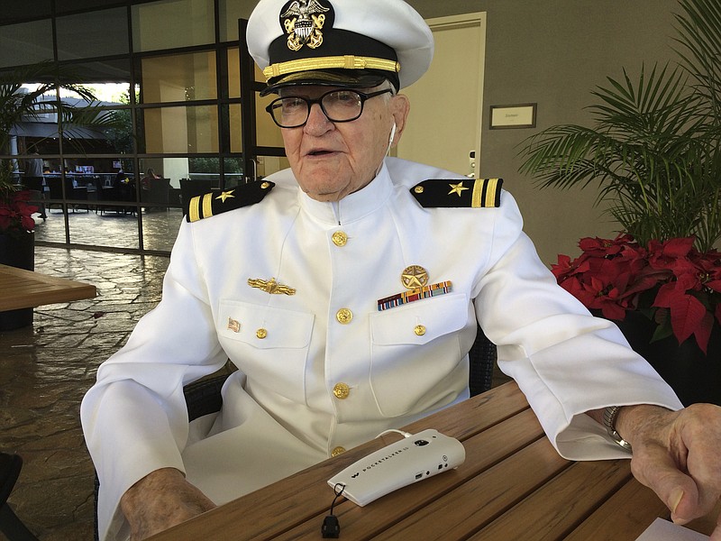 In this Monday, Dec. 5, 2016 photo, Jim Downing, wearing a Navy uniform, answers questions during an interview in Honolulu. Downing is among a few dozen survivors of the Japanese attack on Pearl Harbor who plan to gather at the Hawaii naval base, Wednesday, Dec. 7, 2016, to remember those killed 75 years ago. Thousands of servicemen and women and members of the public are also expected to attend the ceremony. (AP Photo/Audrey McAvoy)